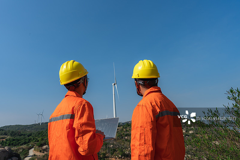 两位电气工程师在风力发电场沟通讨论图片素材