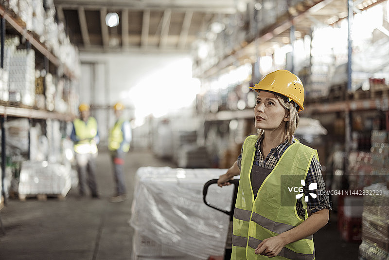 仓库女工拉动托盘车图片素材