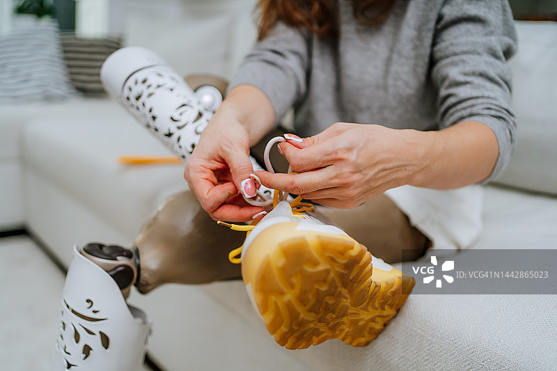 残疾人运动员运动：女子假肢特写，在人造肢体鞋上系鞋带图片素材