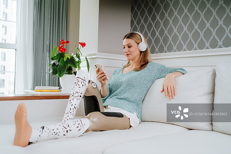 播客和广播，戴耳机听音乐。放松的金发女人用智能手机上网图片素材