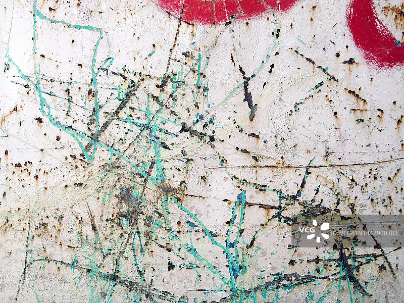 巴黎的锈迹斑斑金属板上的白色、蓝绿色和红色油漆，有风化和划痕图片素材