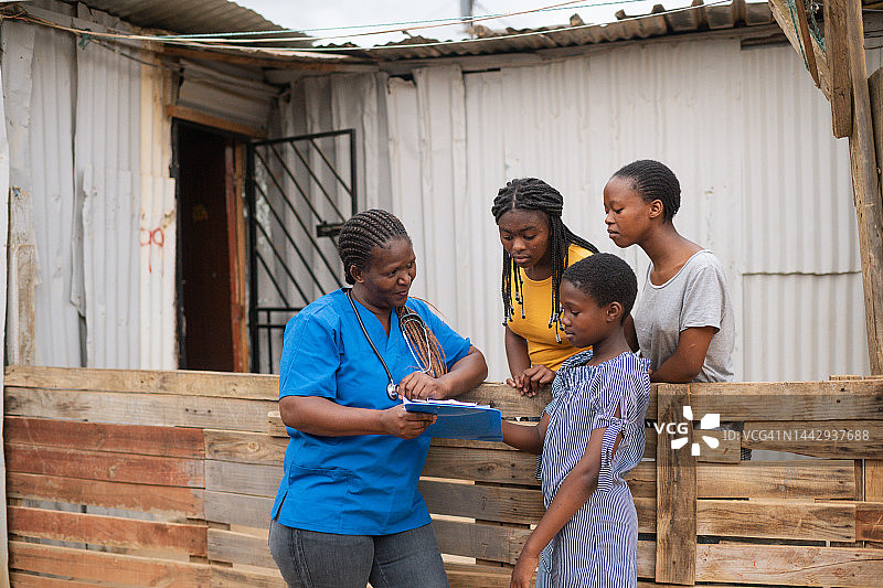 社区护士与棚户区少女交谈图片素材