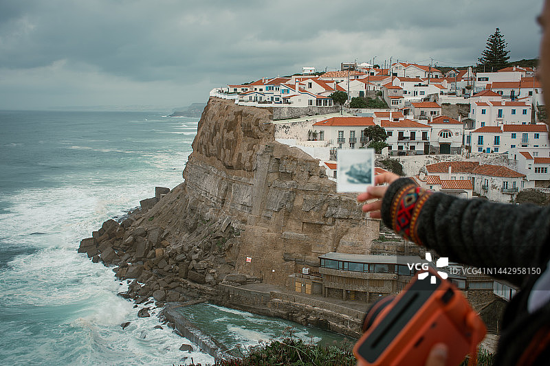 男子手持阿泽尼亚斯·杜·马尔即时照片的视角图片素材