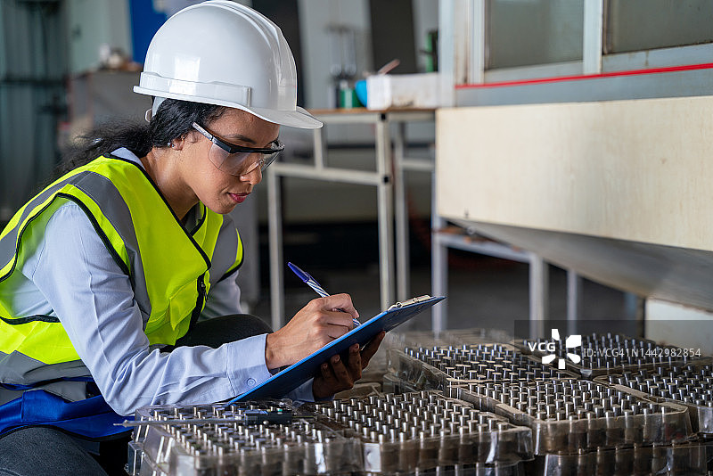 女工在生产线上检查汽车零部件图片素材