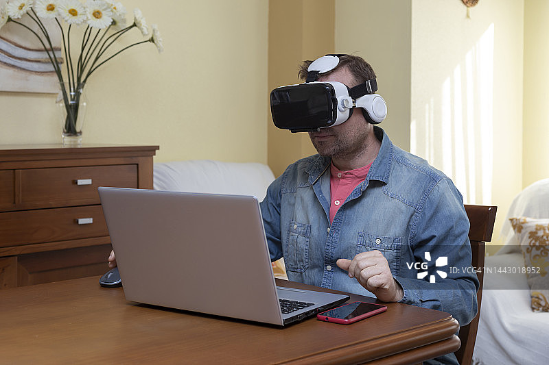 男人使用VR眼镜通过电脑进行游戏空间学习图片素材
