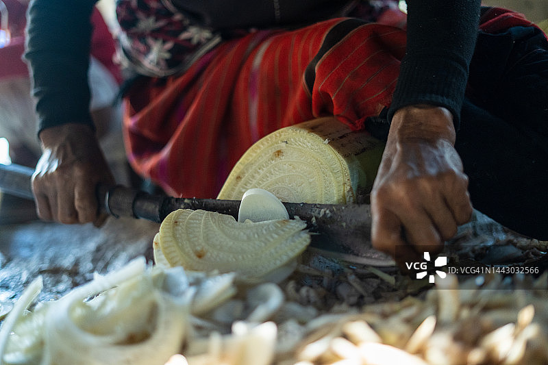 泰国清迈，一位年长的苗族妇女用刀切割有机食物图片素材