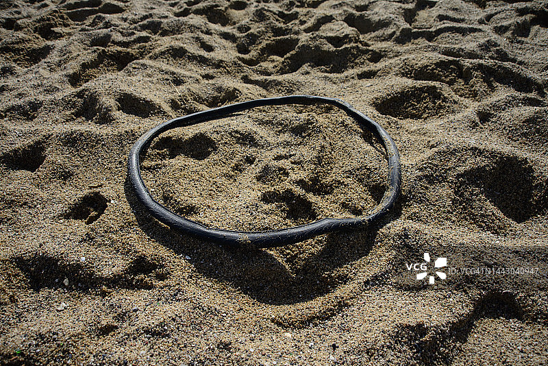 沙滩上丢弃的自行车轮胎图片素材