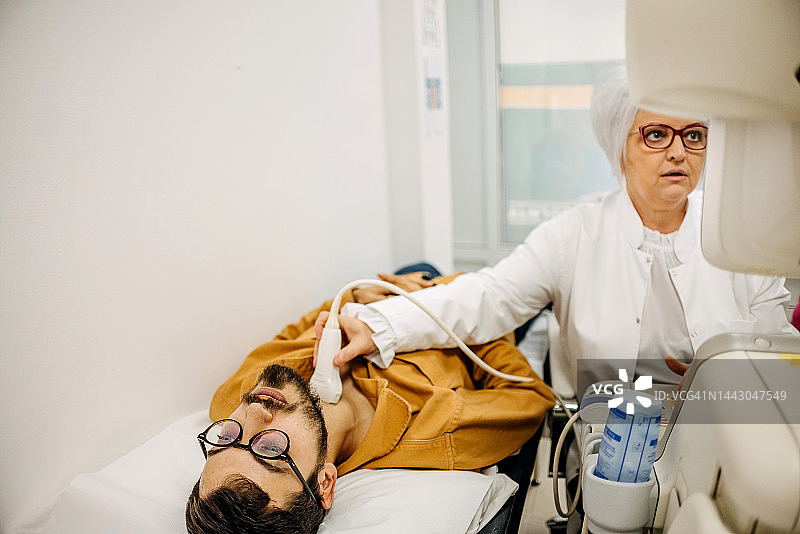 年轻男人接受甲状腺超声波检查图片素材