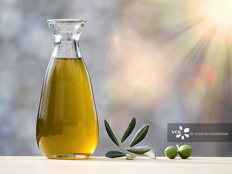 阳光照射下的橄榄油瓶和成熟橄榄图片素材