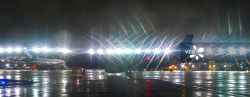 在暴风雨之夜的航站楼前等待的商用飞机图片素材