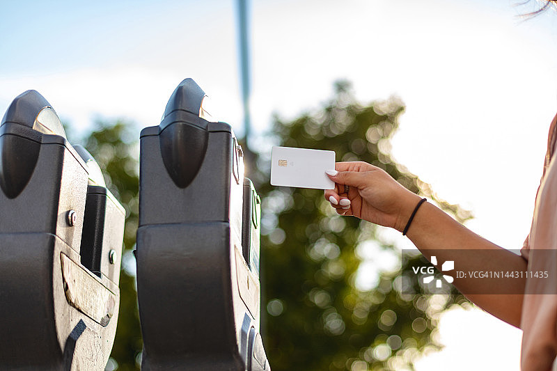 在美国小镇商业区停车场使用信用卡和电子设备支付的西班牙裔美国白人女性摄影系列图片素材