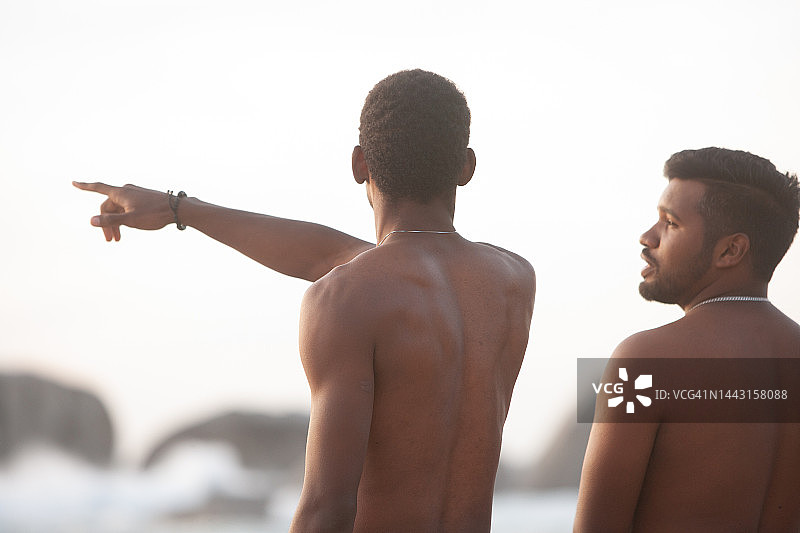 一位英俊的赤膊年轻人向朋友指出一些事情图片素材