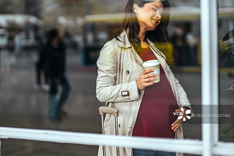 孕妇在上班途中抚摸肚子图片素材