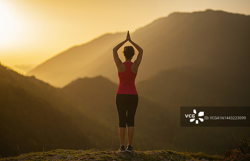 年轻女人在森林里练习瑜伽图片素材