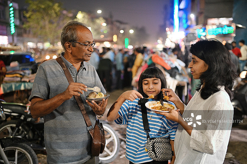 多代家庭游客享用街头美食图片素材