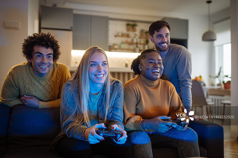 多元朋友在家玩视频游戏和举办派对图片素材