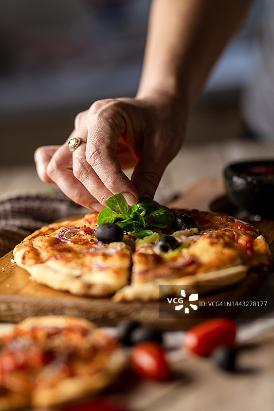 在木制底座上切割和装饰乡村自制披萨图片素材
