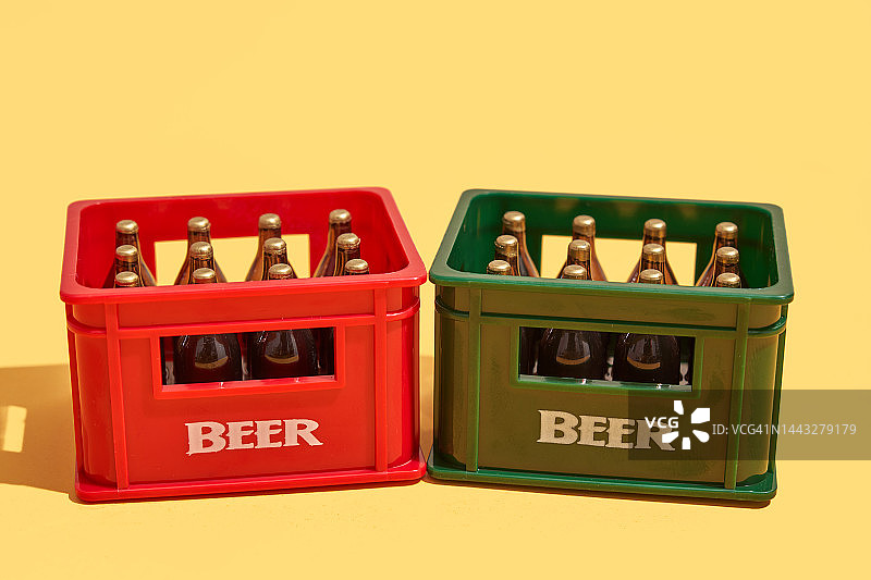 黄色背景上的两个装有啤酒瓶的塑料箱图片素材
