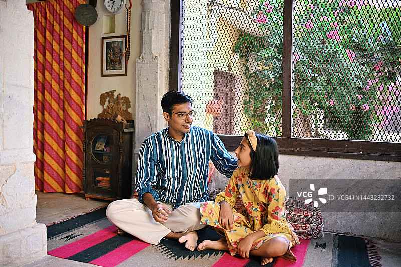 中年男人和女儿坐在地板上聊天图片素材