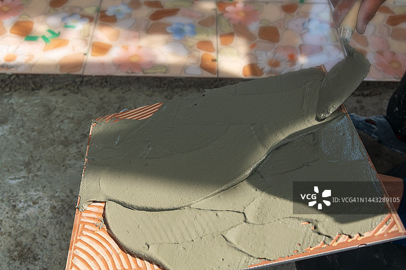 瓦工正在铺设前廊瓷砖。图片素材