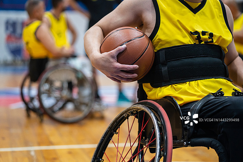 轮椅篮球运动员夹着球图片素材