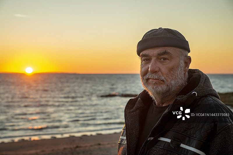 退休老人在海滩欣赏日落图片素材