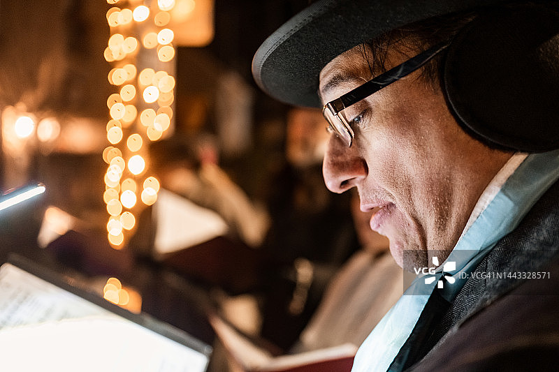 中年男人在户外夜晚唱圣诞颂歌图片素材