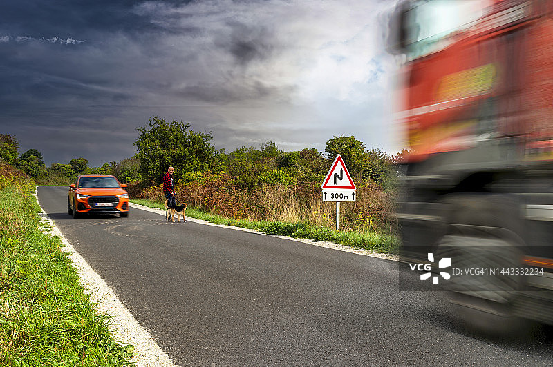 男子带狗在车流中过马路图片素材