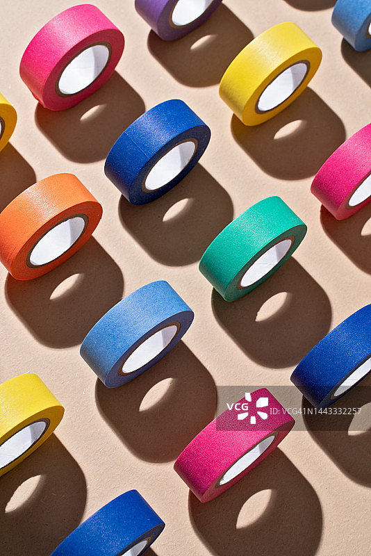 在牛皮纸上滚动的彩色遮蔽胶带图片素材