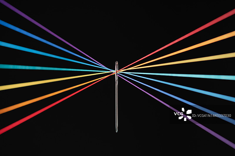 彩虹色细绳穿过针眼汇聚图片素材