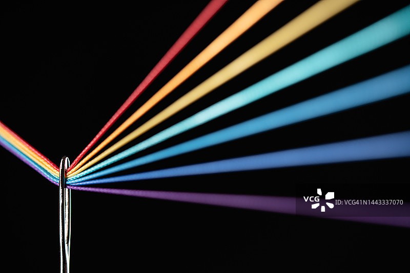 彩色线穿过针眼的彩虹折射图片素材