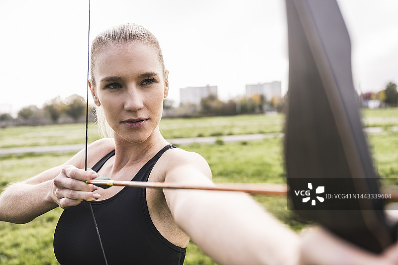 自信的年轻女运动员练习射箭图片素材