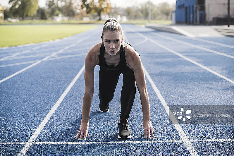 在跑道起跑线上的年轻女运动员图片素材