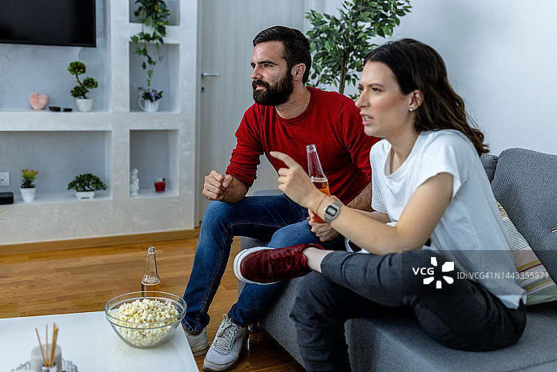 年轻夫妇在家观看足球比赛图片素材