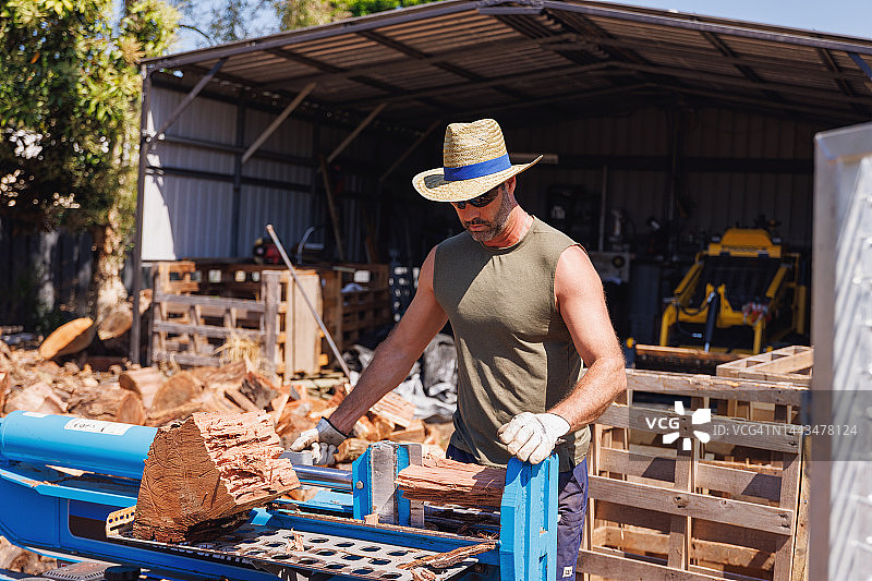 澳大利亚男子用劈木机制作木柴图片素材