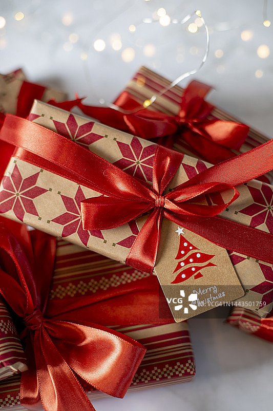 大理石背景上带有祝贺标签的红色圣诞礼盒图片素材