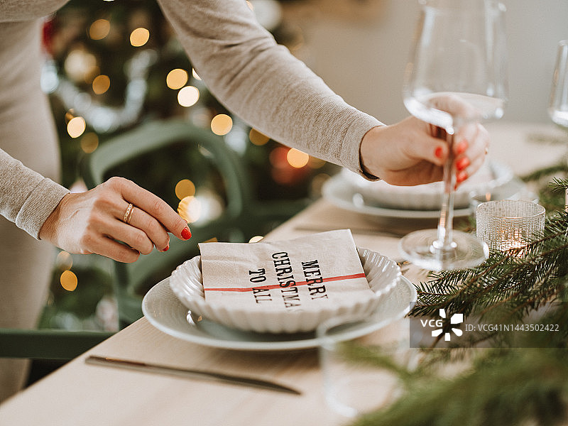 女人准备圣诞餐桌，准备参加晚宴图片素材