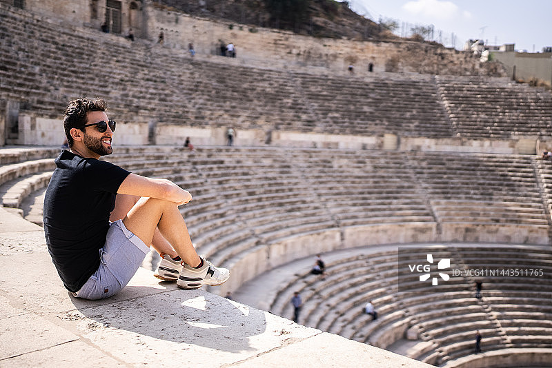 中年男人在约旦安曼的古老圆形剧场图片素材
