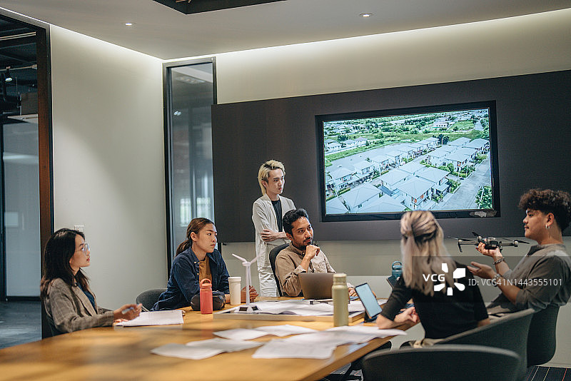 在会议室展示太阳能电池板技术的商务人士图片素材