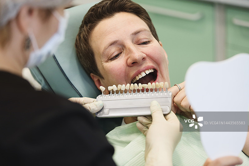 牙医和患者在诊所选择种植牙的颜色图片素材