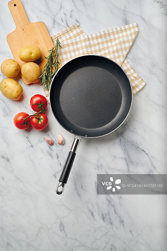 大理石桌上带砧板和蔬菜的空锅图片素材
