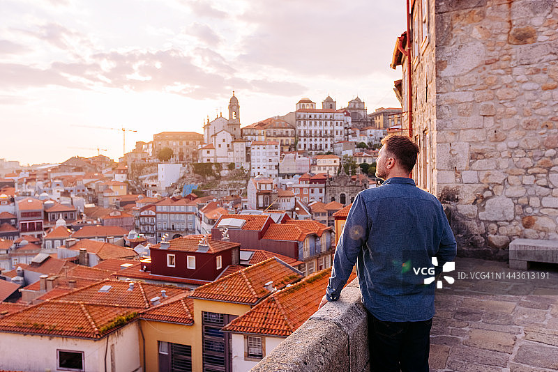 日落时分男人看着葡萄牙波尔图老城的天际线图片素材