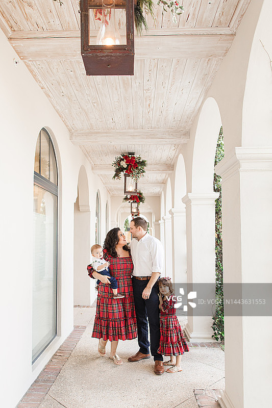 年轻的美国家庭,一家四口穿着喜庆的红色格子花呢服装,在2022年12月于南佛罗里达州拍摄圣诞全家福图片素材