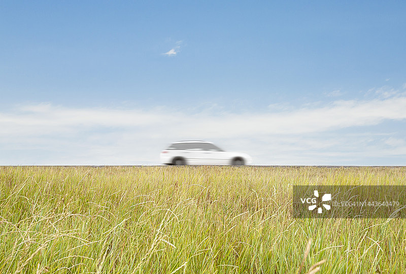 在乡村道路上飞驰的白色汽车图片素材