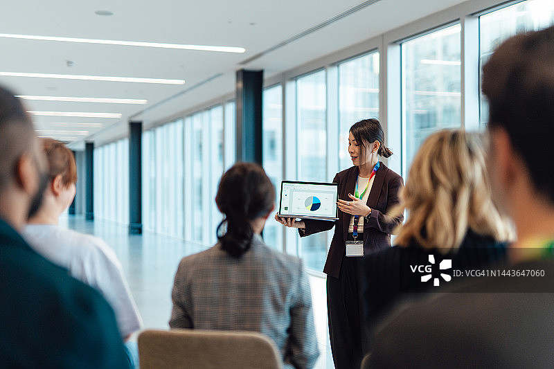 年轻的亚洲女商人在会议室的会议上用笔记本电脑向观众展示图片素材