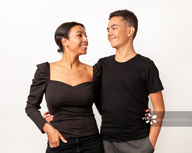 在白色背景下，快乐的非裔美国人母亲与青少年儿子在工作室的合影图片素材