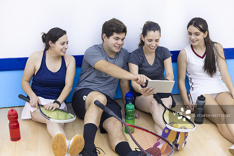壁球队员高兴地在平板电脑上看比赛图片素材