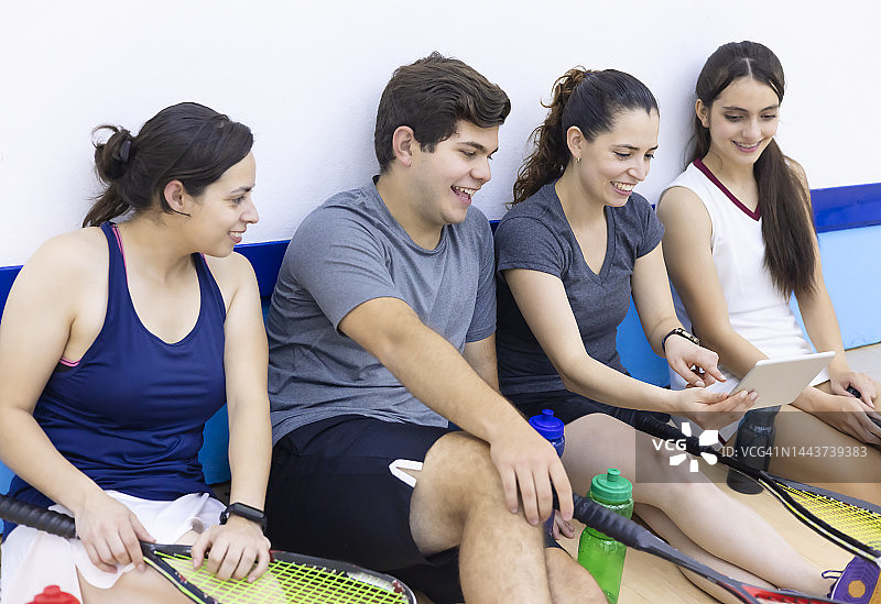 快乐地与技术互动的壁球团队图片素材