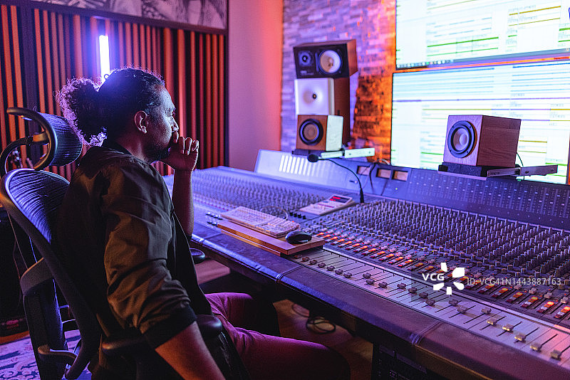 在录音室里看着电脑屏幕的黑人男性音响工程师图片素材