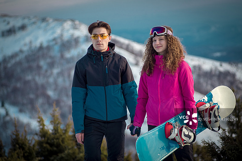 在山顶享受大自然并手牵手的年轻夫妇图片素材